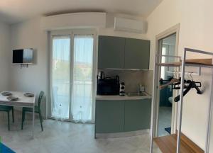 a small kitchen with a small table and a room with a table and a kitchen at Casa di Bea 2 in Ventimiglia