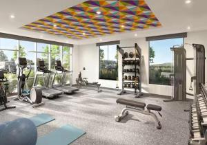 a gym with treadmills and exercise equipment and windows at Home2 Suites By Hilton Hazleton in Hazleton