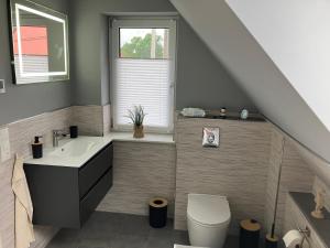 a bathroom with a sink toilet and a window at Ferienwohnung am Woezer See in Woez +8 photos