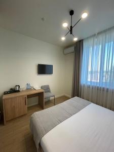 a bedroom with a bed and a desk and a television at Farmer`s Hotel in Pereiaslav-Khmelnytskyi +19 photos