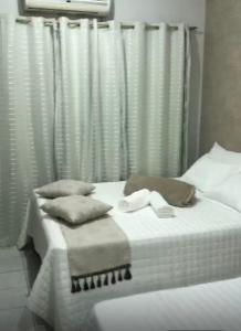 a bed with white sheets and pillows in a bedroom at Hotel Familiar in Salinas