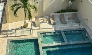 two swimming pools in a building with chairs and palm trees at Hotel y Cabañas Covemar in Coveñas