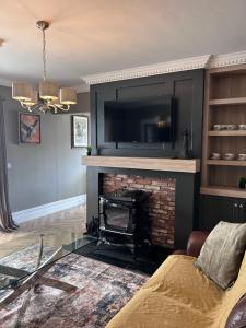 a living room with a fireplace with a tv above it at Creagh Road House in Ballinrobe