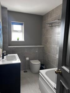a bathroom with a toilet and a sink and a tub at Creagh Road House in Ballinrobe +18 photos