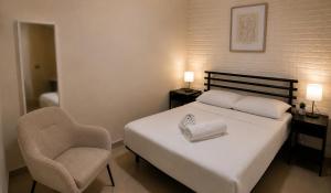a bedroom with a bed and a chair at Milano Suite in Lev Eilat in Eilat