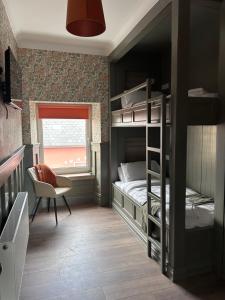 a bedroom with a bunk bed and a chair and a window at Creagh Road House in Ballinrobe