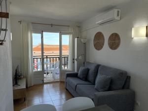 a living room with a couch and a balcony at Costa Arenal 112 in Arenal d'en Castell