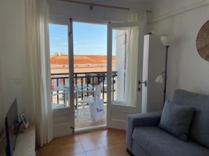 a living room with a door open to a balcony at Costa Arenal 112 in Arenal d'en Castell