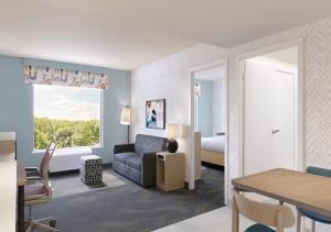 a living room with a couch and a bedroom at Home2 Suites By Hilton Hazleton in Hazleton