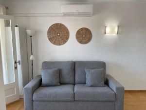 a blue couch in a living room with two pillows at Costa Arenal 112 in Arenal d'en Castell +15 photos