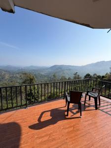 a balcony with two benches and a view of the mountains at Mystik Muthu View Haputale in Haputale