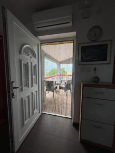 a door leading to a patio with a table and chairs at Lydia in Vrsi