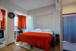 a bedroom with a bed with a red blanket at Maremy in Zadar