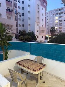a table and chairs on the balcony of a building at Aouina Stay in El Aouina Station