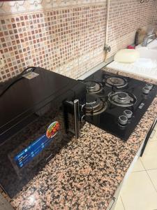 a kitchen counter with a black stove top oven at Aouina Stay in El Aouina Station