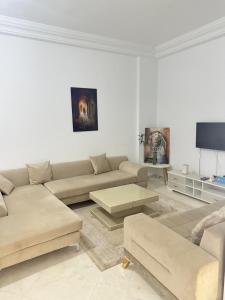 a living room with a couch and a table at Aouina Stay in El Aouina Station