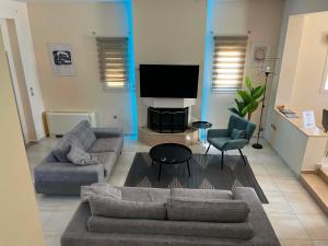a living room with a couch and chairs and a television at Villa Stergos in Kremasti