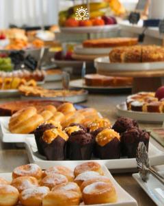 a bunch of different types of pastries on plates on a table at HOTEL BLUE SKY in Rimini
