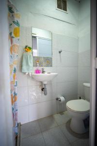 a bathroom with a sink and a toilet and a mirror at Cabaña la Arenosa in Coveñas +45 photos