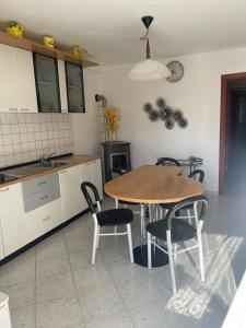 a kitchen with a wooden table and chairs at Casa dolce casa in Gorfigliano
