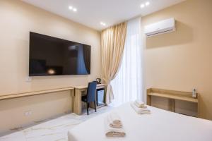a hotel room with two beds and a television on the wall at Bologna Rooms in Naples