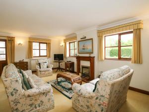 a living room with two chairs and a fireplace at Willow Cottage in North Lydbury