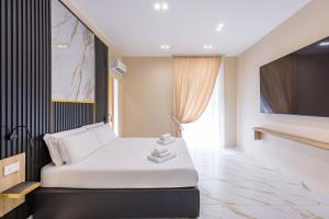 a bedroom with a white bed and a large window at Bologna Rooms in Naples
