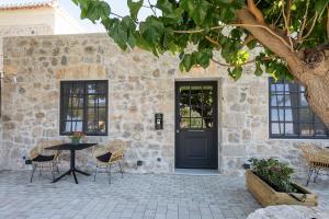 a patio with a black door and a table and chairs at Argolis Rodies Homes in Kilada
