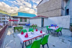a group of tables and chairs on a patio at Gaunney Valley - Tirthan Valley in Manāli