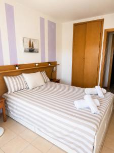 a bedroom with a large bed with towels on it at Salou Beach Apartment with private Pool in Salou +10 photos
