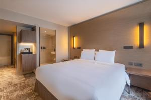 a large white bed in a hotel room at Radisson Blu CDG Airport Terminal Hotel, Paris in Tremblay-En-France +92 photos