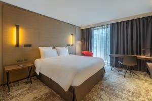 a hotel room with a large bed and a desk at Radisson Blu CDG Airport Terminal Hotel, Paris in Tremblay-En-France