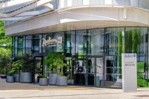a glass building with a sign in front of it at Radisson Blu CDG Airport Terminal Hotel, Paris in Tremblay-En-France