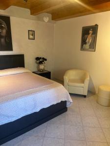 a bedroom with a bed and a chair at Casa dolce casa in Gorfigliano