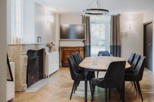 a dining room with a table and chairs and a television at Les Demeures de Varennes, BW Signature Collection in Varennes-Jarcy
