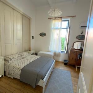 a bedroom with a bed and a window at Marys Central Beachside Mansion in Agios Nikolaos