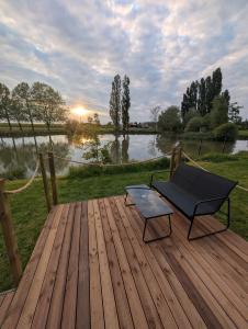 a wooden deck with a bench and a chair on it at Camping de Graçay in Graçay