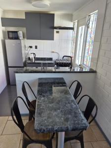 a kitchen with a table with chairs and a counter top at Amoblados Copiapo in Copiapó
