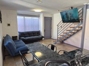 a living room with a couch and a tv on the wall at Amoblados Copiapo in Copiapó
