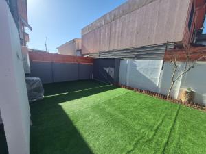 a patio with green grass on the side of a building at Amoblados Copiapo in Copiapó