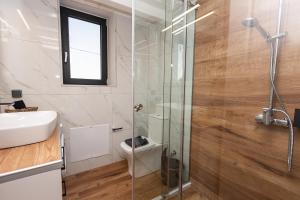 a bathroom with a shower and a toilet and a sink at Argolis Rodies Homes in Kilada +46 photos
