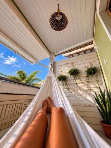 a person laying in a hammock on a porch at MeldoMar chalé aconchegante na Pipa in Pipa