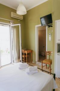 a bedroom with a bed and a tv on the wall at Anna Christina in Kamena Vourla