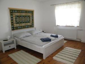 a bedroom with a bed and a window at Sártekerő Vendégház in Alsópáhok +4 photos
