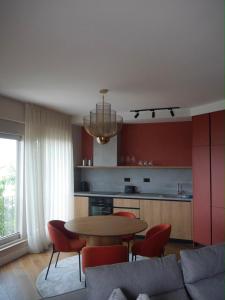 a living room with a table and red chairs at Apartment Marta Tivat in Tivat
