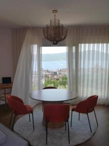 a table and chairs in a room with a large window at Apartment Marta Tivat in Tivat +6 photos