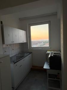 a kitchen with a large window and a counter at Ring Urban Apartment in Kosovo Polje