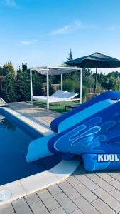 a blue water slide next to a swimming pool at EtyekZen in Etyek