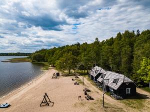 a group of cabins on the shore of a lake at Lukstas Rest Park in Graužai