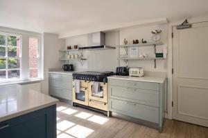 a kitchen with white counters and a stove top oven at Abbey House by Group Retreats in Saffron Walden